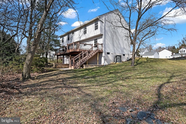 back of house with stairway, a deck, and a yard