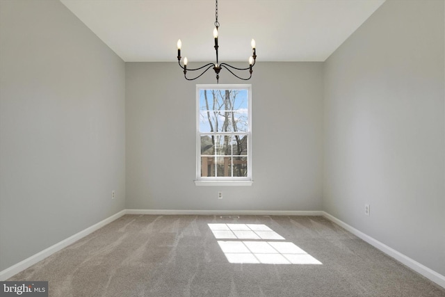 unfurnished dining area featuring carpet floors, a chandelier, and baseboards