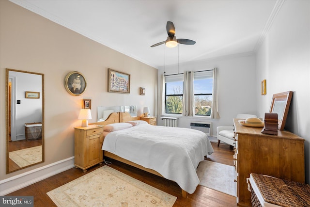 bedroom with dark wood finished floors, radiator, ornamental molding, a ceiling fan, and baseboards