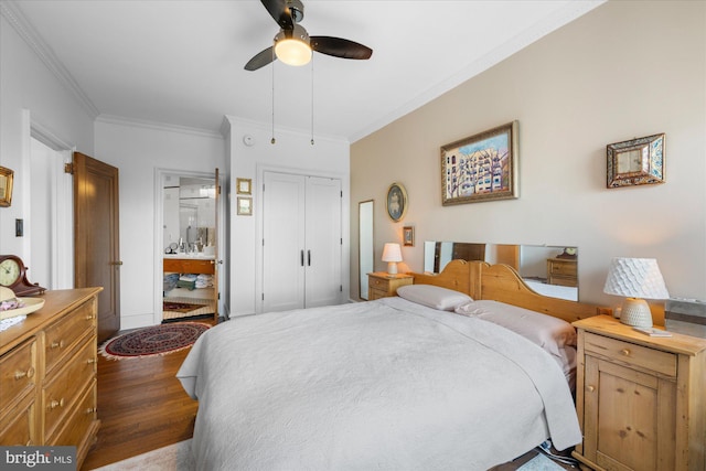 bedroom featuring dark wood-style floors, a closet, ornamental molding, connected bathroom, and ceiling fan