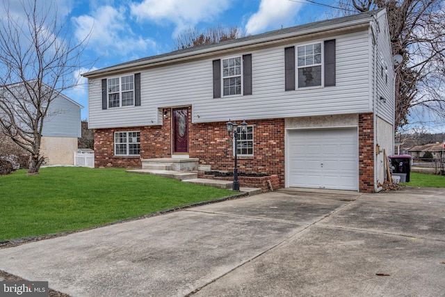 raised ranch with driveway, an attached garage, a front yard, and brick siding