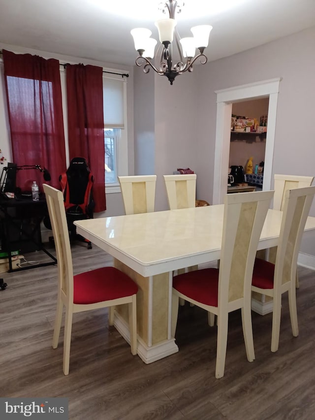 dining room with dark wood-style floors and a chandelier