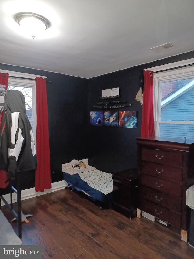 bedroom featuring baseboards, visible vents, and wood finished floors