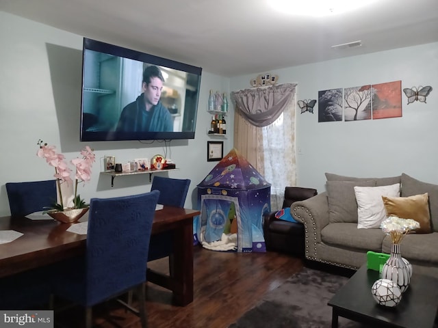 living area with wood finished floors and visible vents