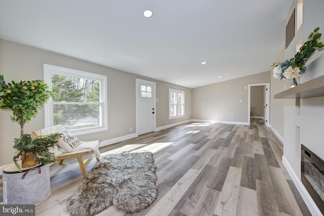 unfurnished living room featuring recessed lighting, light wood-style flooring, and baseboards