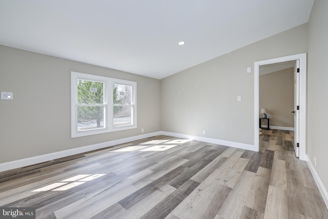 spare room with recessed lighting, light wood-type flooring, and baseboards