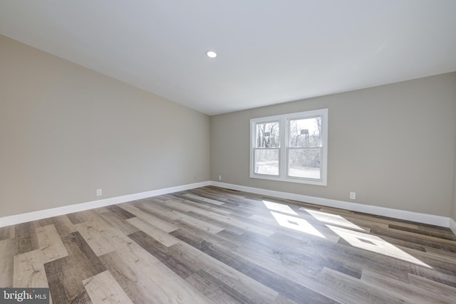 empty room with recessed lighting, baseboards, and wood finished floors