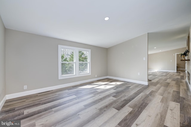 unfurnished room featuring visible vents, recessed lighting, baseboards, and wood finished floors