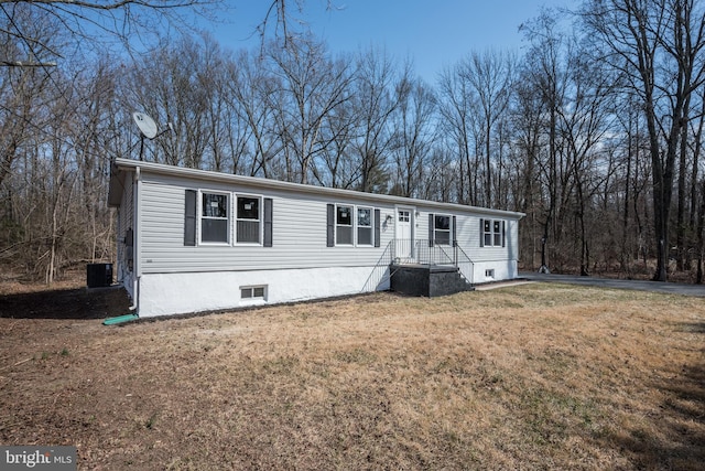 manufactured / mobile home featuring central AC unit and a front yard