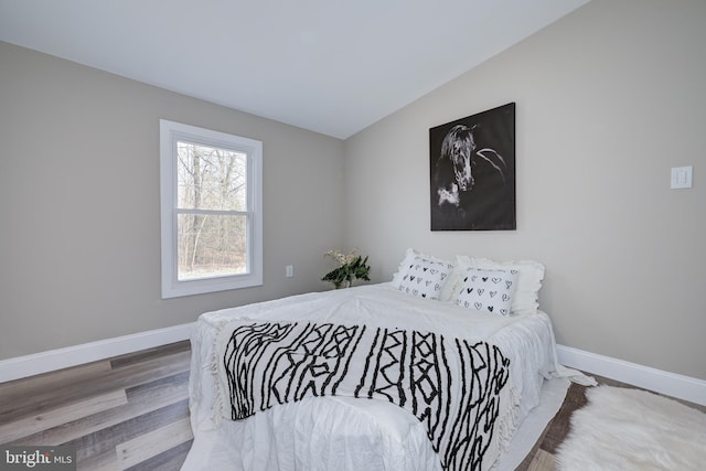 bedroom with baseboards and wood finished floors