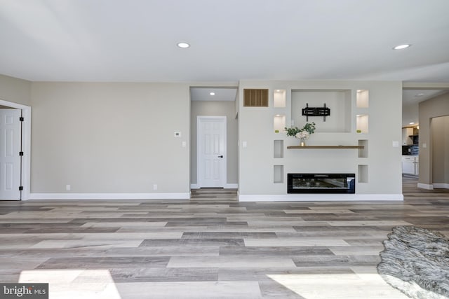 living room with recessed lighting, visible vents, and baseboards