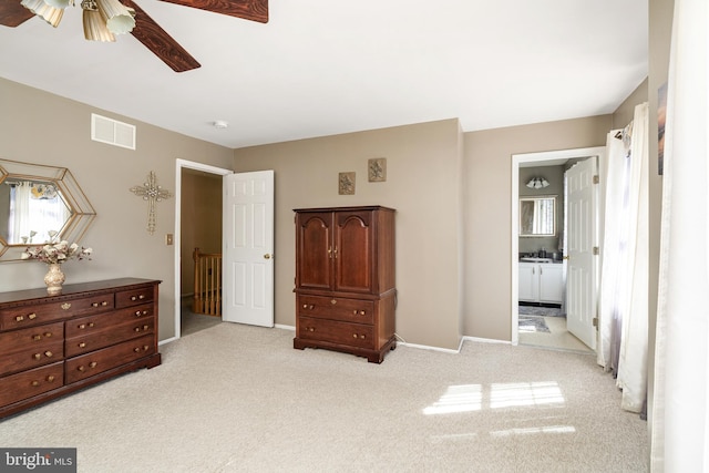 bedroom featuring light colored carpet, visible vents, baseboards, and ensuite bathroom