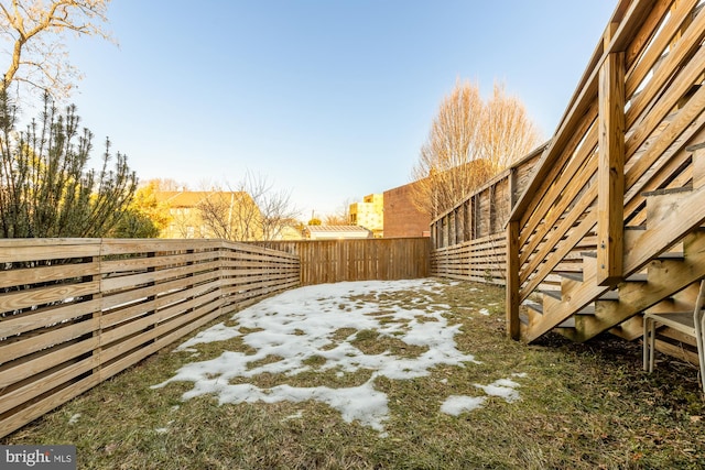 yard layered in snow with a fenced backyard