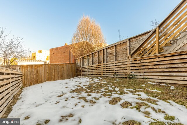 yard layered in snow featuring fence