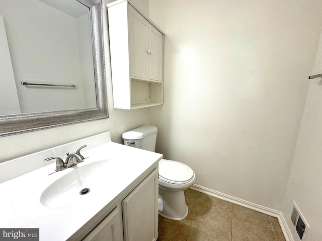 bathroom with visible vents, toilet, vanity, baseboards, and tile patterned floors