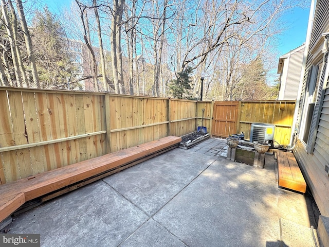 view of patio / terrace featuring central AC unit, fence, and a gate