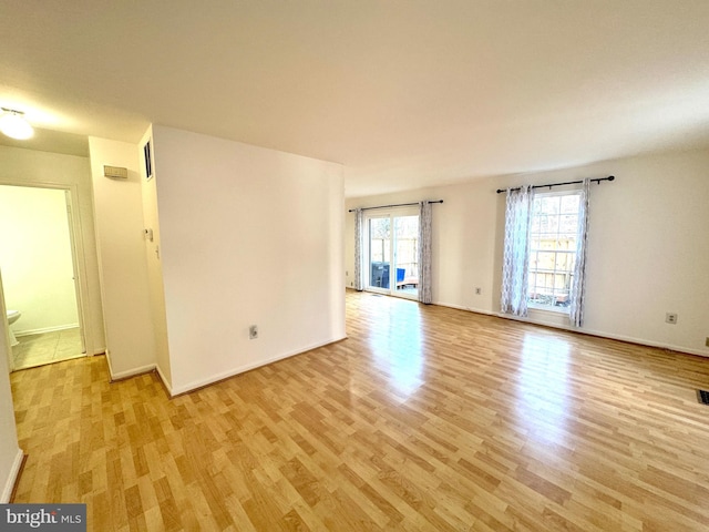 empty room featuring baseboards and light wood-style floors