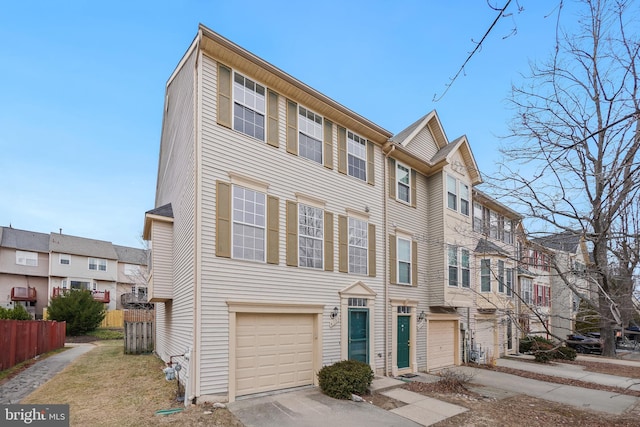 townhome / multi-family property featuring a garage, concrete driveway, and fence