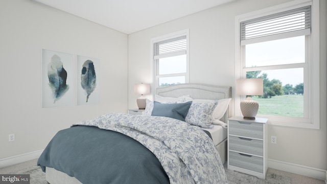 bedroom featuring baseboards, multiple windows, and light colored carpet