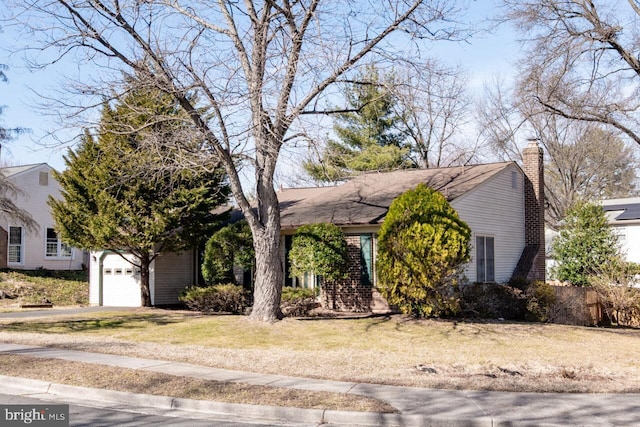 view of front of property featuring a front lawn, an attached garage, and a chimney