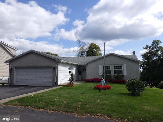 single story home featuring driveway, brick siding, an attached garage, and a front yard