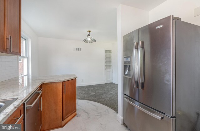 kitchen with appliances with stainless steel finishes, light colored carpet, brown cabinets, and visible vents