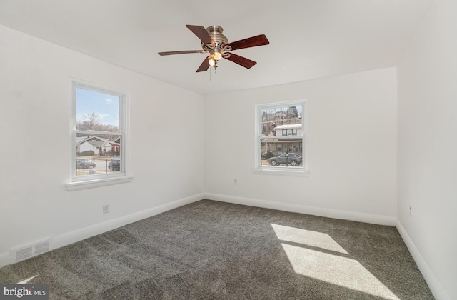 carpeted spare room with baseboards, a ceiling fan, visible vents, and a healthy amount of sunlight