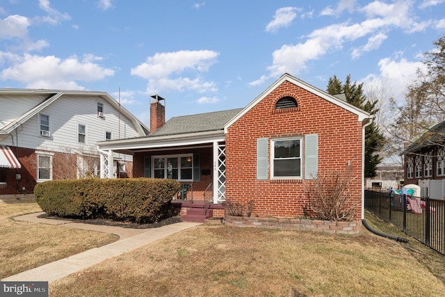 bungalow featuring brick siding, a chimney, covered porch, a front yard, and fence