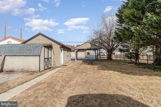 view of yard featuring a storage shed, an outdoor structure, and fence