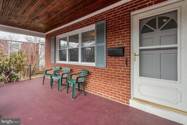 exterior space featuring covered porch and brick siding