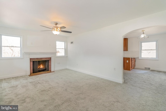 unfurnished living room featuring plenty of natural light, visible vents, and light colored carpet