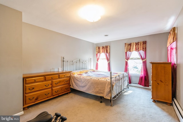 bedroom featuring a baseboard heating unit, baseboards, and light colored carpet