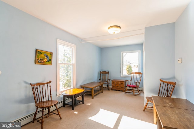 living area featuring light carpet and a baseboard heating unit