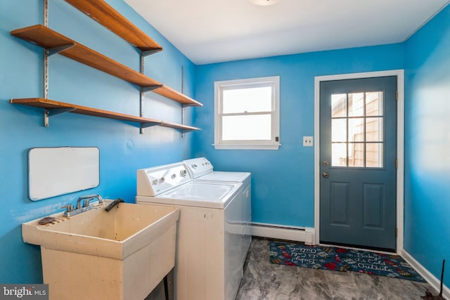 washroom featuring a baseboard heating unit, laundry area, a sink, baseboards, and washer and dryer