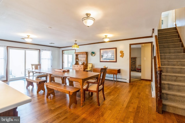 dining area with wood finished floors, baseboards, ornamental molding, stairway, and baseboard heating