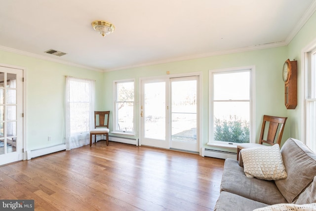 living area featuring light wood finished floors, visible vents, a baseboard radiator, ornamental molding, and a baseboard heating unit