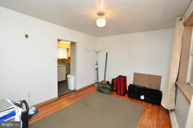 interior space with a sink, baseboards, and wood finished floors