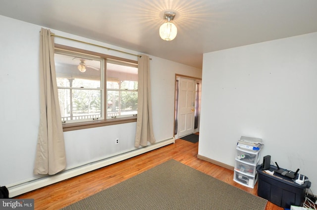 bedroom with a baseboard radiator and wood finished floors