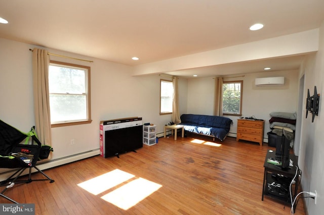 interior space with a wall unit AC, recessed lighting, a baseboard radiator, light wood-style floors, and a baseboard heating unit