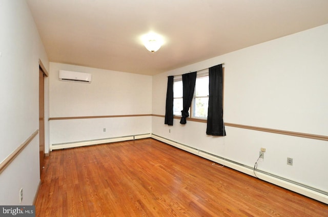 empty room featuring a baseboard heating unit, an AC wall unit, and wood finished floors