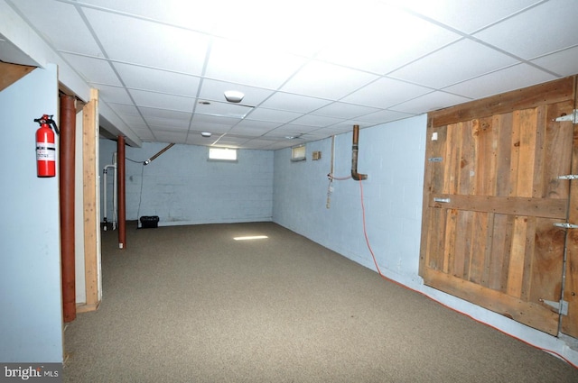 below grade area featuring concrete block wall and a drop ceiling