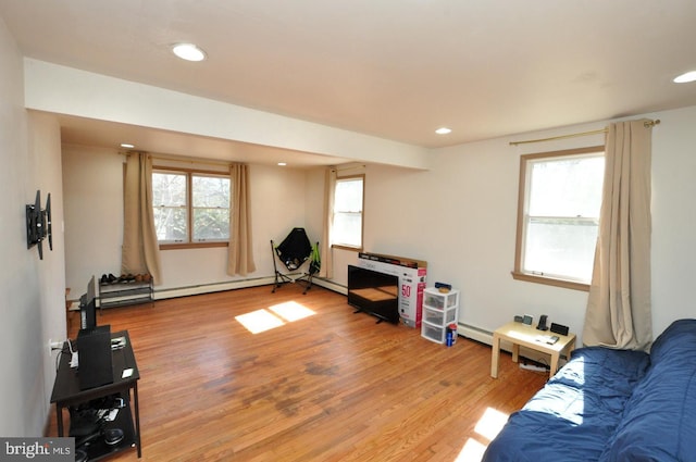 living area featuring a baseboard radiator, recessed lighting, a healthy amount of sunlight, and wood finished floors