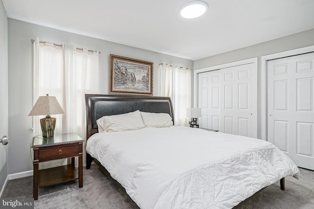 bedroom featuring multiple closets, carpet flooring, and baseboards