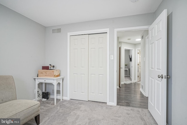 living area featuring baseboards, visible vents, and carpet flooring