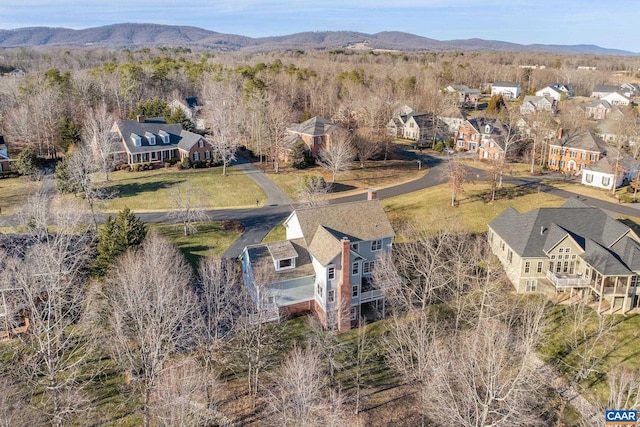 birds eye view of property featuring a residential view, a mountain view, and a view of trees