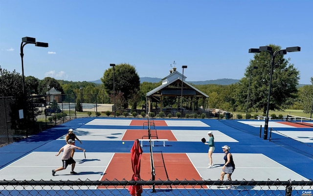 view of home's community featuring a tennis court, fence, and a gazebo