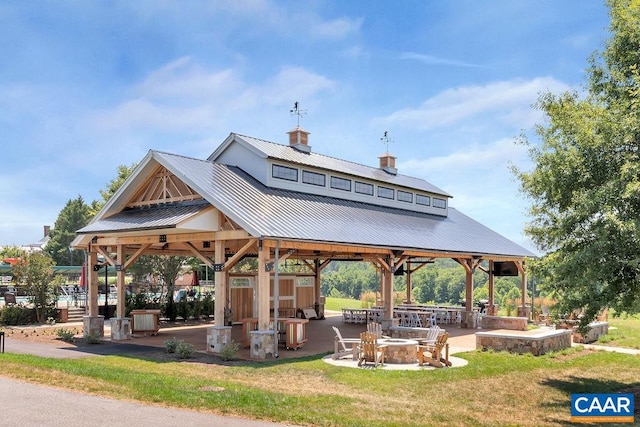 view of property's community with a gazebo, a yard, a patio, and an outdoor fire pit