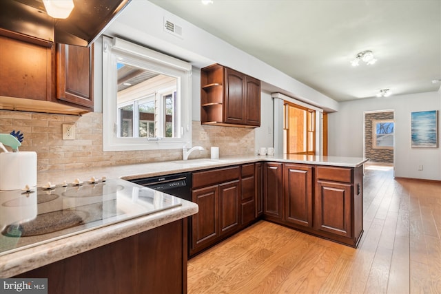 kitchen with open shelves, visible vents, light countertops, light wood-type flooring, and a peninsula