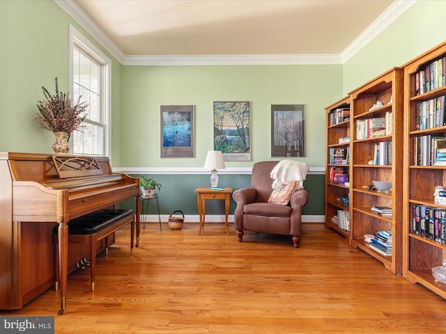 sitting room featuring crown molding, baseboards, and light wood-style floors