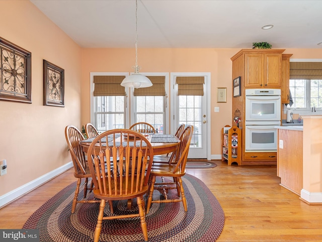 dining space featuring baseboards and light wood-style floors